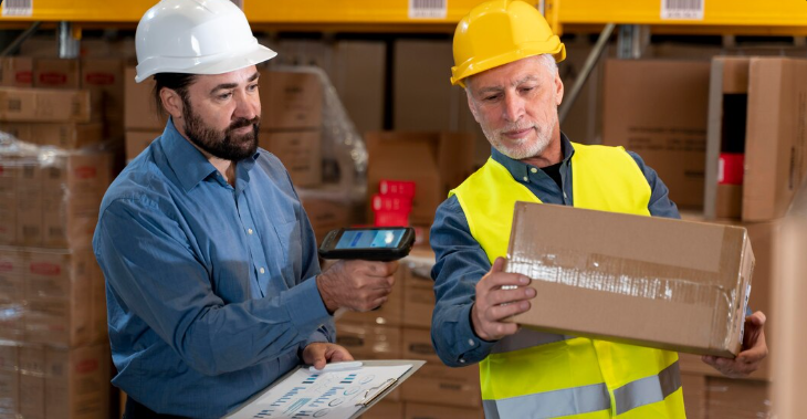 Warehouse employee scanning packages near Amazon system