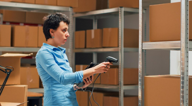 FedEx package handler scanning and sorting packages in a warehouse distribution center in 2026.