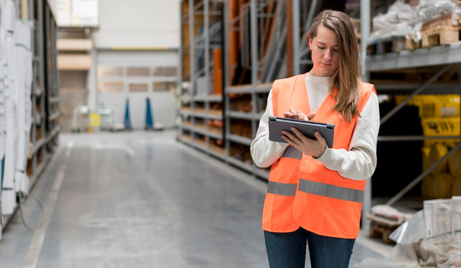 Warehouse worker walking through parts shelving aisles at a dealership warehouse in Conroe Texas 2026