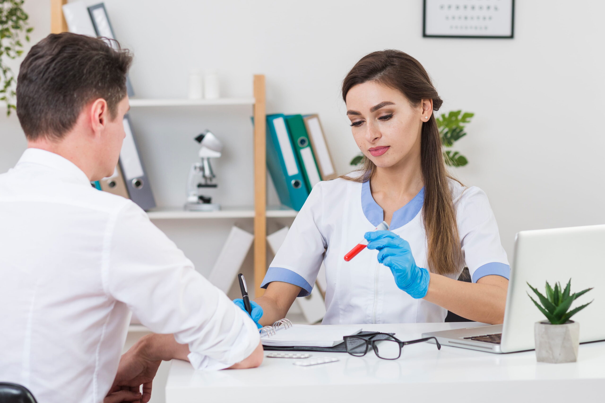 Phlebotomist performing a blood draw in a healthcare clinic.
