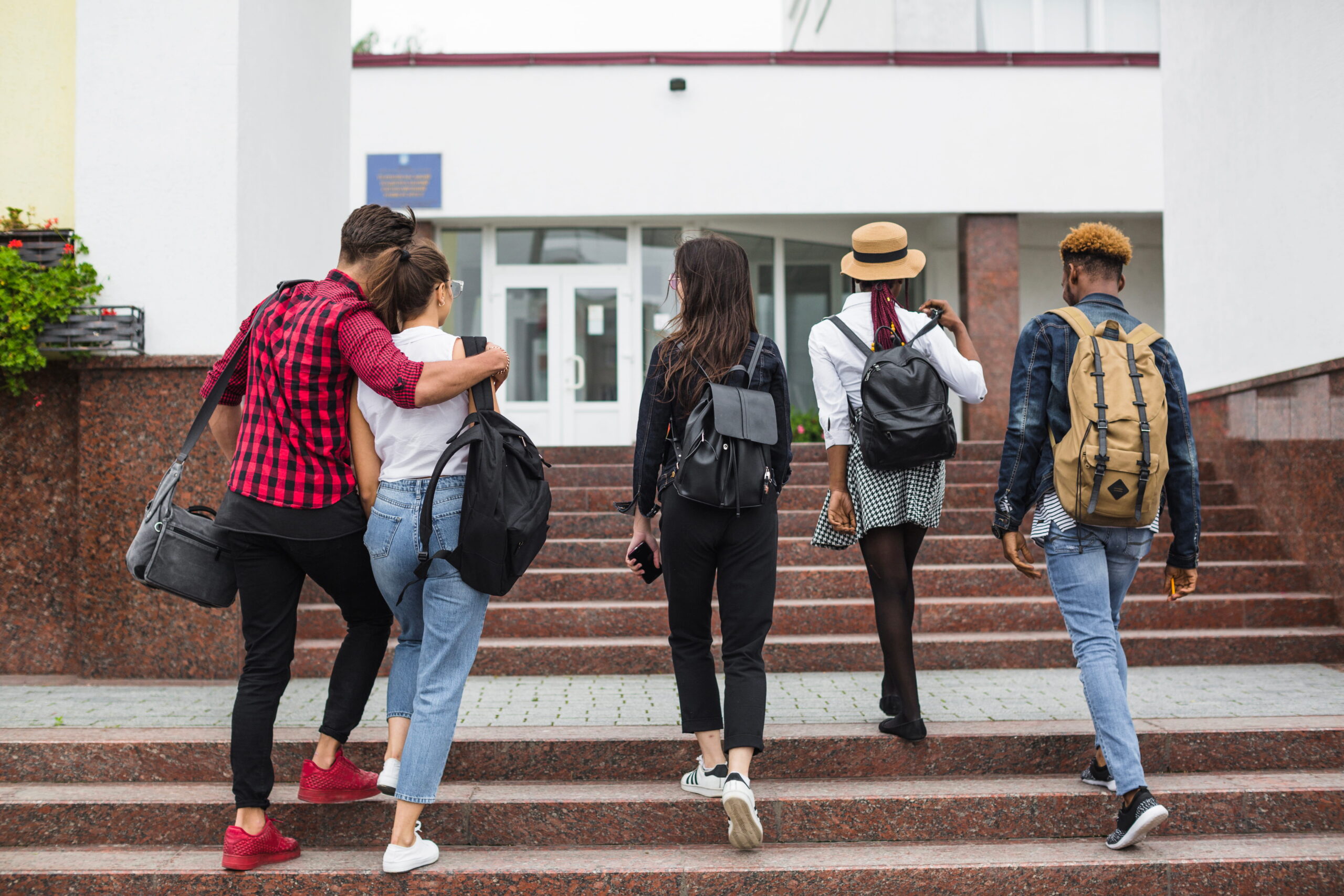 A diverse group of international students walking across a US campus quad with backpacks, used right under the header before the intro starts.