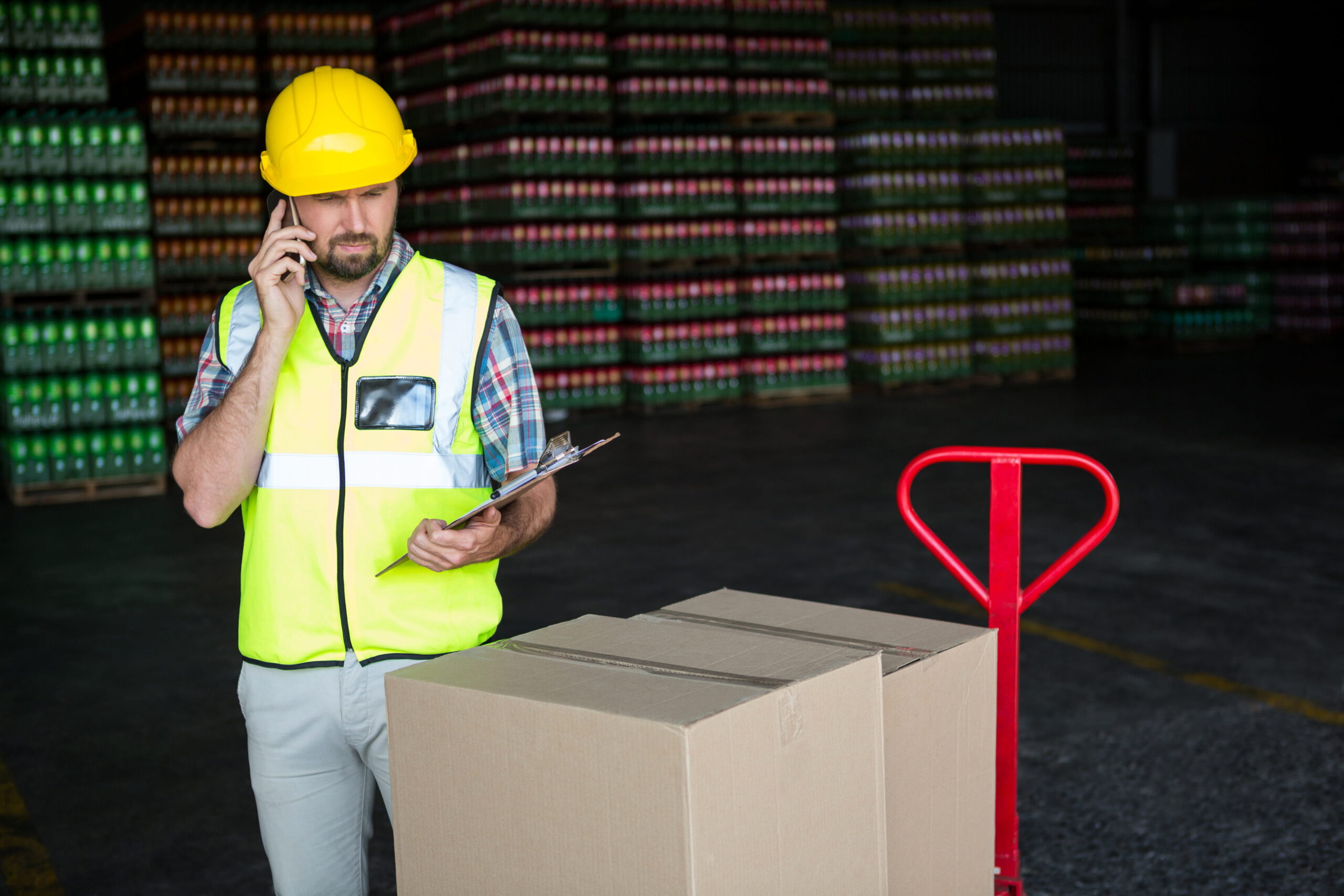 Warehouse worker picking boxes from shelves inside a large distribution center USA